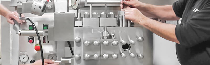 Homogenisator Service Zwei Servicetechniker warten einen mehrstufiger Homogenisator der Baureihe Gaulin von APV