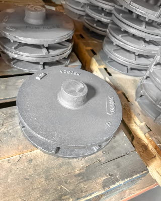 Des ensembles de disques, composants de la pompe à disques, sont posés sur un établi chez le fabricant, dans l'atelier de production des pompes à disques.