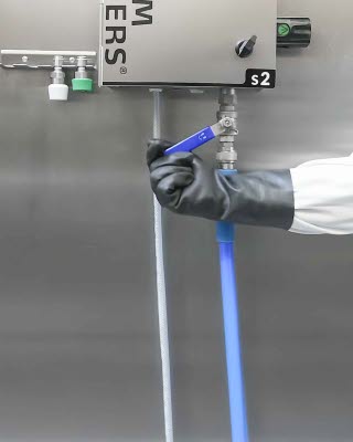 Person mit Handschuhen bet&auml;tigt den Hebel der Reinigungsstation