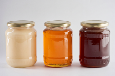 Drei Honigsorten in unterschiedlicher Farbe im Schraubglas. 